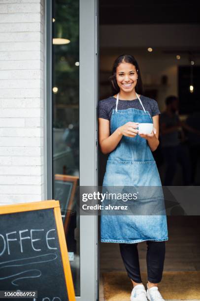 lächelnd lädt die gäste im café barista - women serving coffee stock-fotos und bilder