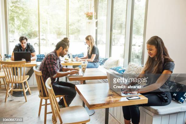 millennials im wlan-café - medium group of people stock-fotos und bilder