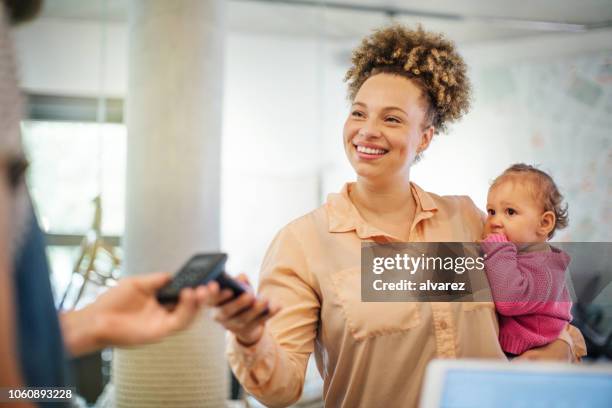 frau bezahlen mit nfc-technologie im café - nfc payment stock-fotos und bilder