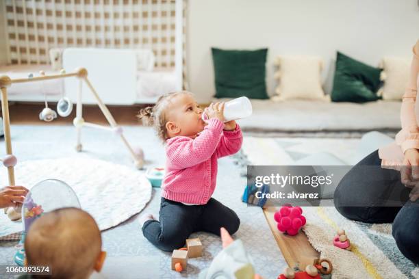 babymädchen trinken milch aus der flasche - toddler milk stock-fotos und bilder