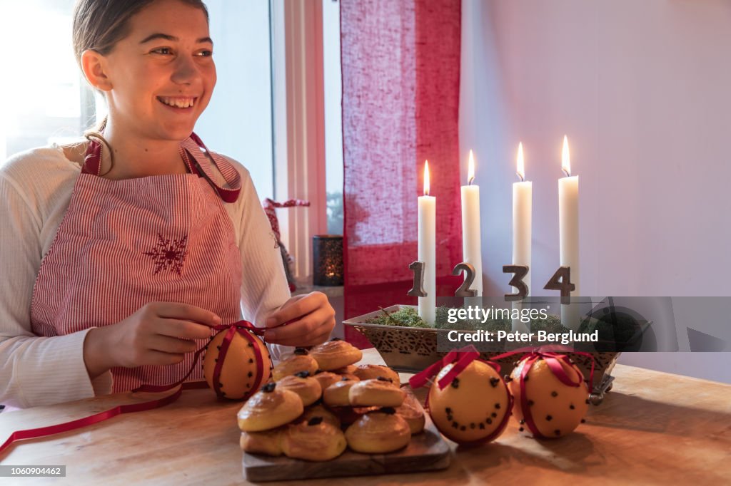 Girl smiling while making Christmas decorations