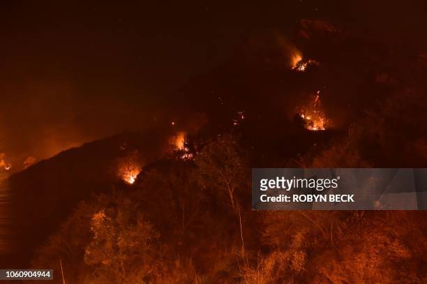 Spot fires burn on the hills above Pepperdine University during the Woolsey fire, November 12, 2018 in Malibu, California. - Another three...