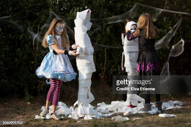 older children playing 'wrap the mummy' halloween game with toilet rolls - wrapped in toilet paper ストックフォトと画像