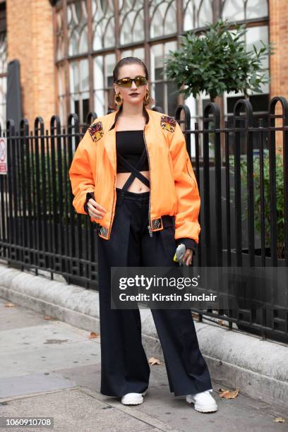 Fashion Designer Jeanne Touzet wears an Asger Juel Larsen jacket, Max Mara trousers, Dr Martens shoes and Chanel earrings during London Fashion Week...