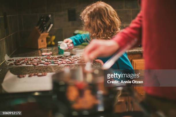 little girl decorates chocolate covered pretzels - kids cooking christmas photos et images de collection