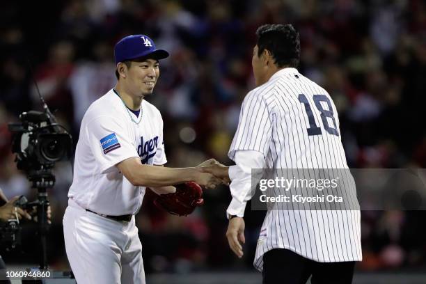 Former pitcher Hiroki Kuroda shakes hands with Pitcher Kenta Maeda of the Los Angeles Dodgers after throwing a ceremonial first pitch prior to the...