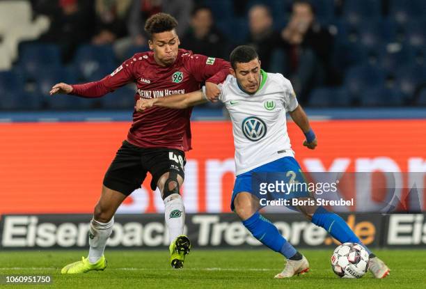 William of VfL Wolfsburg is challenged by Linton Maina of Hannover 96 during the Bundesliga match between Hannover 96 and VfL Wolfsburg at HDI-Arena...
