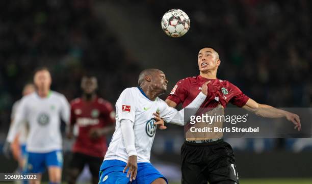 Jerome Roussillon of VfL Wolfsburg battles for the ball with Bobby Wood of Hannover 96 during the Bundesliga match between Hannover 96 and VfL...