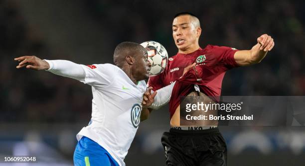 Jerome Roussillon of VfL Wolfsburg battles for the ball with Bobby Wood of Hannover 96 during the Bundesliga match between Hannover 96 and VfL...