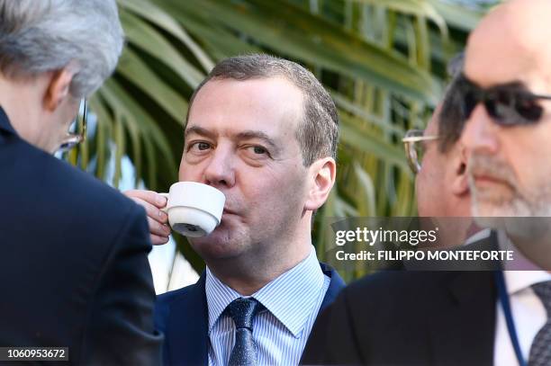 Russian Prime Minister Dmitry Medvedev drinks a cup of coffee on November 13, 2018 during an international conference on Libya at Villa Igiea in...