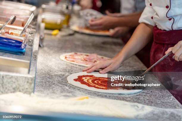 chef using ladle to spread sauce on a pizza - make stock pictures, royalty-free photos & images