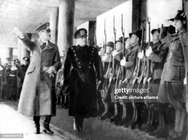 Adolf Hitler and Italian Prime Minister and Duce Benito Mussolini walking down an honor guard during their meeting at the Brenner Pass on 18 March...