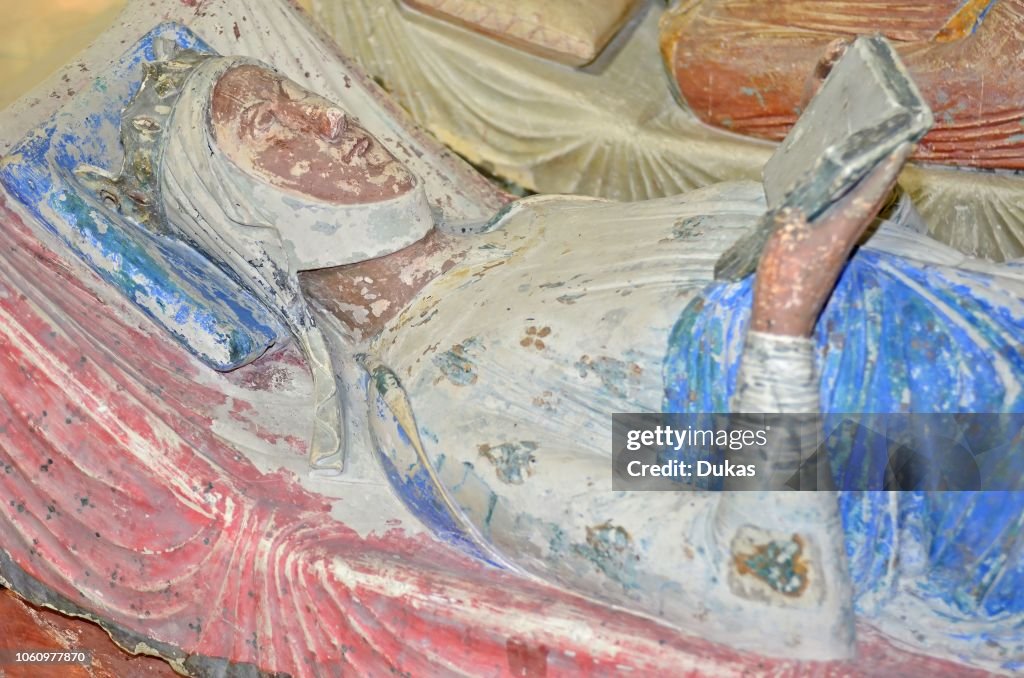 The 800 year old tomb of Eleanor of Aquitaine, Queen of England represented reading her bible