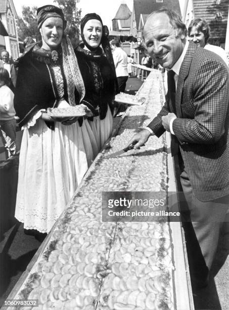 Der ehemalige Fußball-Nationalspieler Uwe Seeler schneidet am 20.5.1984 auf dem Steinkirchener Frühjahrsmarkt den wohl längsten Apfelkuchen der Welt...