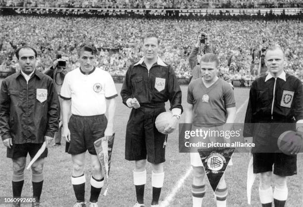 Hungary's team captain Ferenc Puskas and Germany's team captain Fritz Walter are standing between referee William Ling and linesmen Vincenzo...