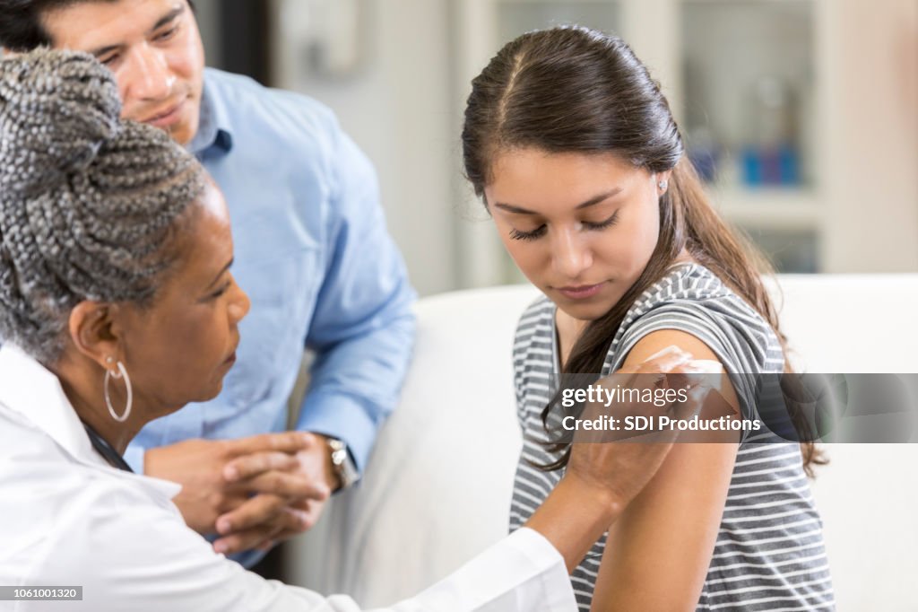 Teenage girl prepares for vaccination at doctor