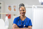 Portrait of confident senior female doctor in scrubs