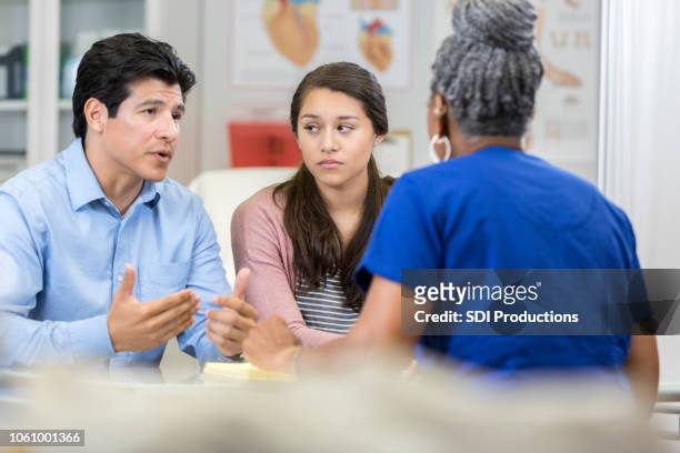 teen girl and father speak with cardiologist - jaded pictures stock pictures, royalty-free photos & images