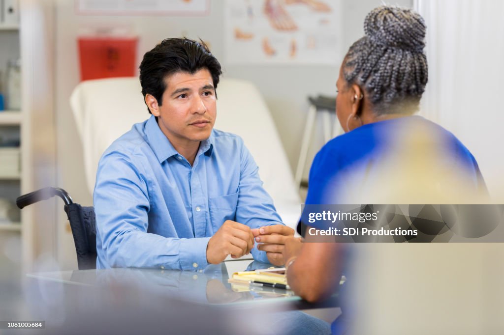 Man discusses physical injury recovery with doctor