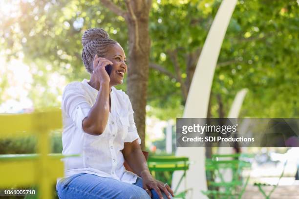一名高級婦女坐在戶外在高級中心, 而呼叫家庭 - glamourous granny 個照片及圖片檔