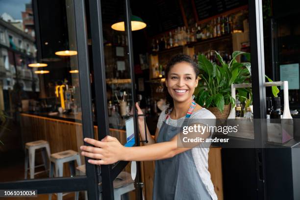 happy business owner opening the door at a cafe - restaurant owner stock pictures, royalty-free photos & images