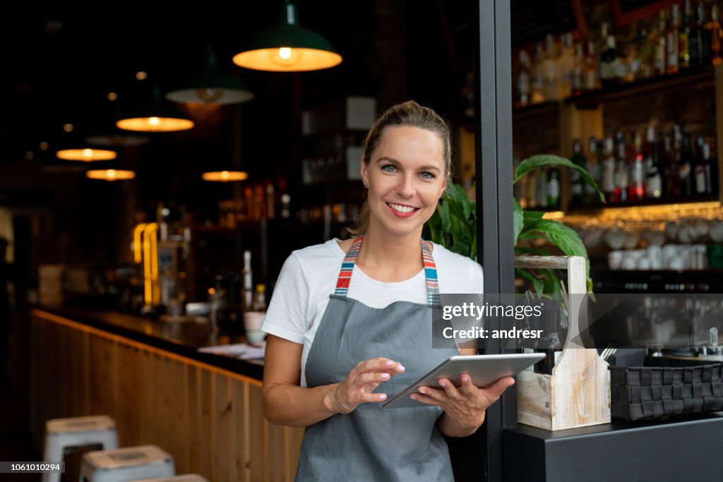 Waitress working at a cafe using a tablet computer