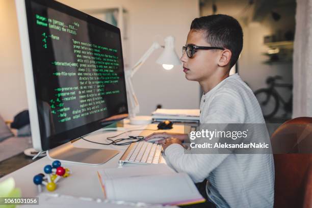 pre-adolescent boy programming at computer - teen programming book stock pictures, royalty-free photos & images