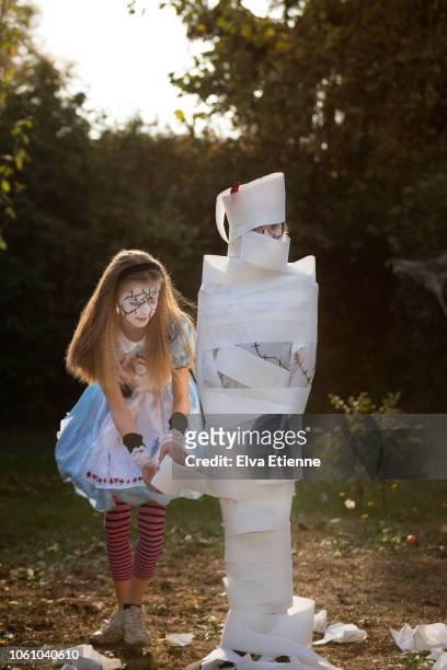 two girls playing 'wrap the mummy' halloween game with toilet roll - wrapped in toilet paper stock pictures, royalty-free photos & images