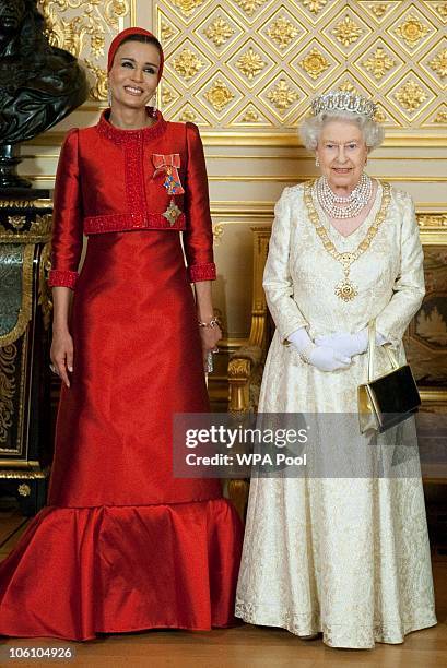 Queen Elizabeth II poses with Sheikha Mozah bint Nasser Al Missned, the wife of Qatar's Emir Sheikh Hamad bin Khalifa al Thani, before a banquet held...