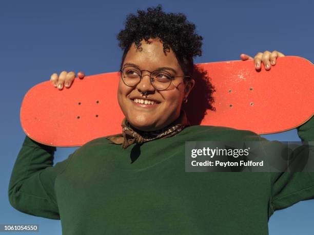 smiling woman with orange skateboard - body positive 個照片及圖片檔