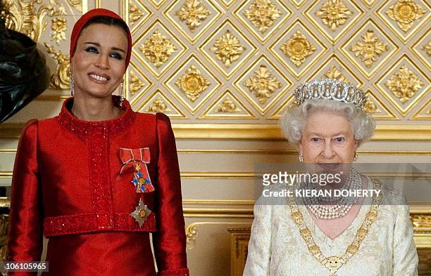 Britain's Queen Elizabeth poses with Sheikha Mozah bint Nasser Al Missned, the wife of Qatar's Emir Sheikh Hamad bin Khalifa al Thani, before a...