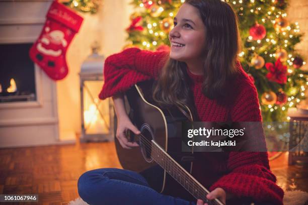 teenage girl playing the guitar - christmas singing stock pictures, royalty-free photos & images