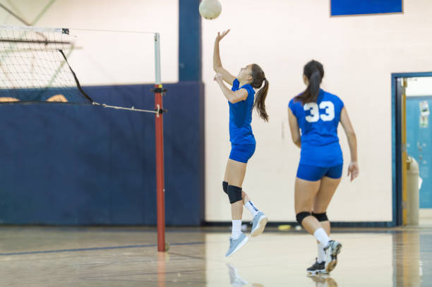 high school volleyball player returns a volley - girls volleyball stock pictures, royalty-free photos & images