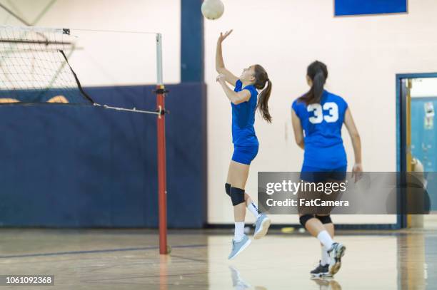 high school volleyball player returns a volley - girls volleyball stock pictures, royalty-free photos & images
