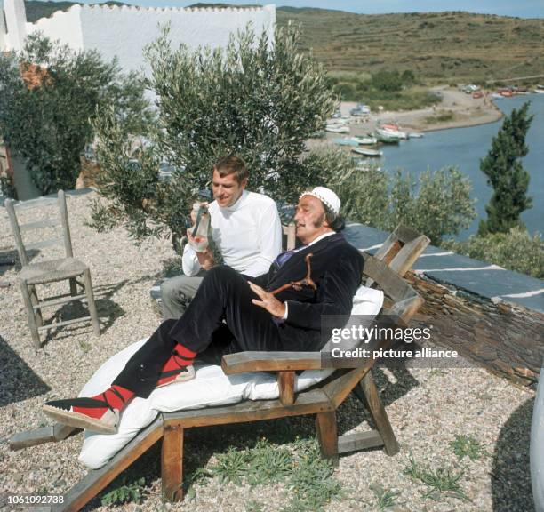 Spanish artist Salvador Dali on the grounds of his residence near Cadaques on 17 September 1968 talking to a journalist.