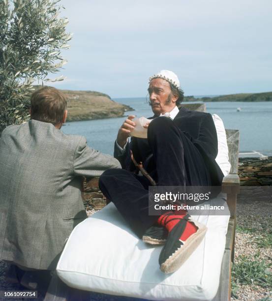 Spanish artist Salvador Dali on the grounds of his residence near Cadaques on 17 September 1968 talking to a journalist.
