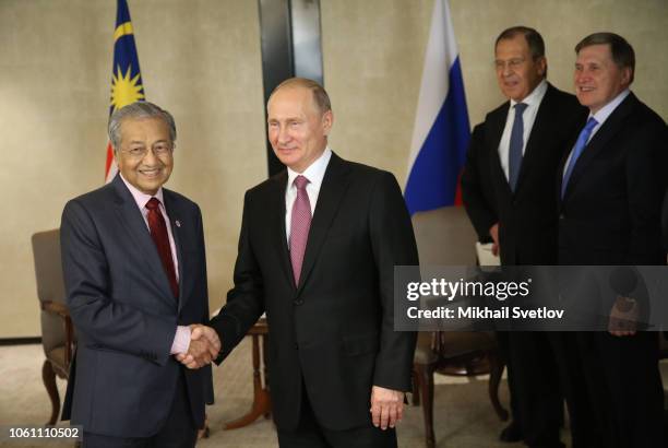 Russian President Vladimir Putin greets Malaysian Prime Minister Mahathir Mohamad as Russian Foreign Minister Sergei Lavrov and Presidential Aide...