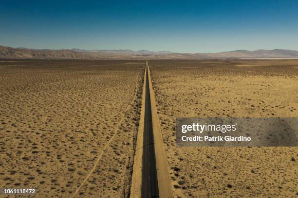 arial view of empty road in the desert - arial desert stock-fotos und bilder