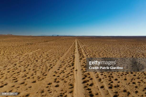 arial view of empty road in the desert - arial desert stock-fotos und bilder