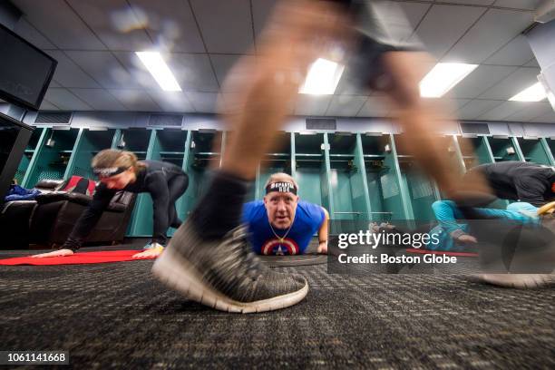 Participants do push-ups in the visitors locker room during the Spartan Fenway Park Stadium Sprint at Fenway Park in Boston on Nov. 10, 2018. Some...