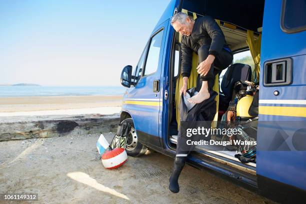 senior diver getting into wetsuit. - old people diving stock pictures, royalty-free photos & images