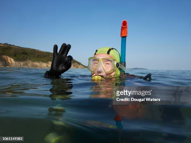 positive senior diver at sea. - old people diving stock pictures, royalty-free photos & images