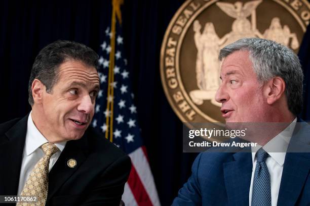 New York Governor Andrew Cuomo and New York City Mayor Bill de Blasio talk with each other during a press conference to discuss Amazon's decision to...