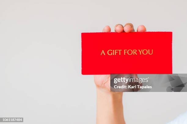 a christmas card with a phrase saying "a gift for you" - hand holding card stock-fotos und bilder