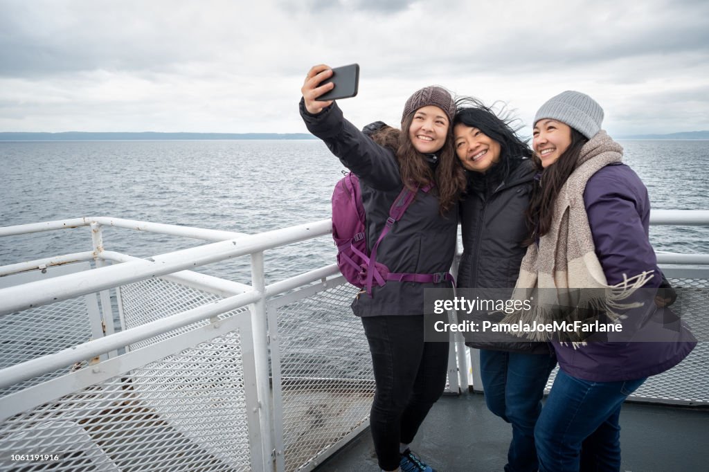 Winter Travel on Ferry, Mother and Teen Daughters Taking Selfie