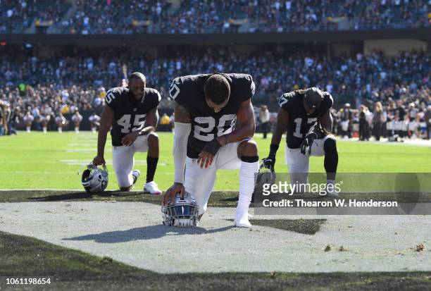 Daryl Worley, Dominique Rodgers-Cromartie and Dwayne Harris of the Oakland Raiders kneel and pray prior to the start of their game against the...