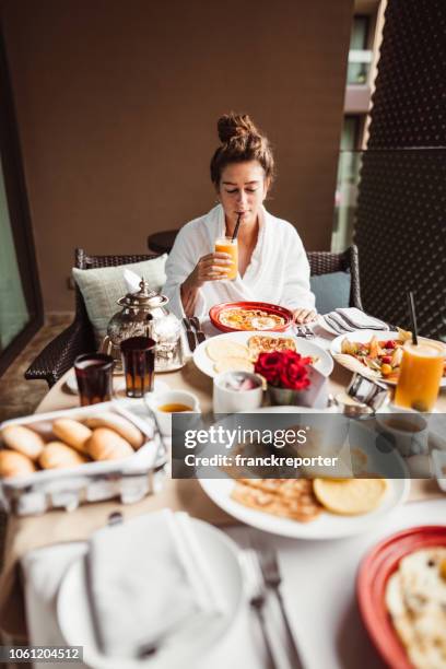 femme à la table pour le petit déjeuner buffet avec fruits - hotel breakfast photos et images de collection