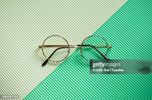 a flat lay of a pair of round-shaped eye glasses - pair stock photos et images de collection