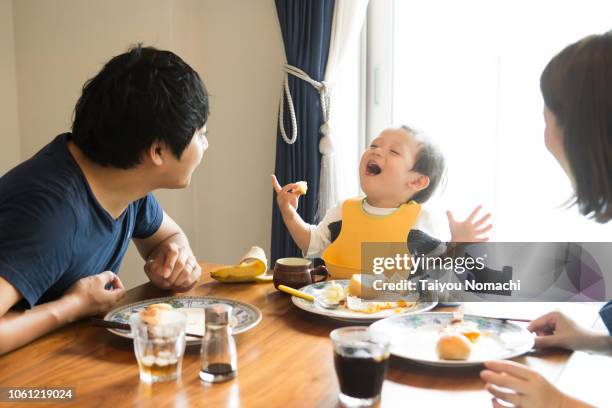 family who speaks with a smile while eating breakfast - parent and child meal stock pictures, royalty-free photos & images