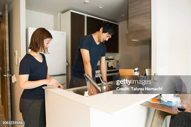 husband washing dishes and watching wife - the japanese wife - fotografias e filmes do acervo